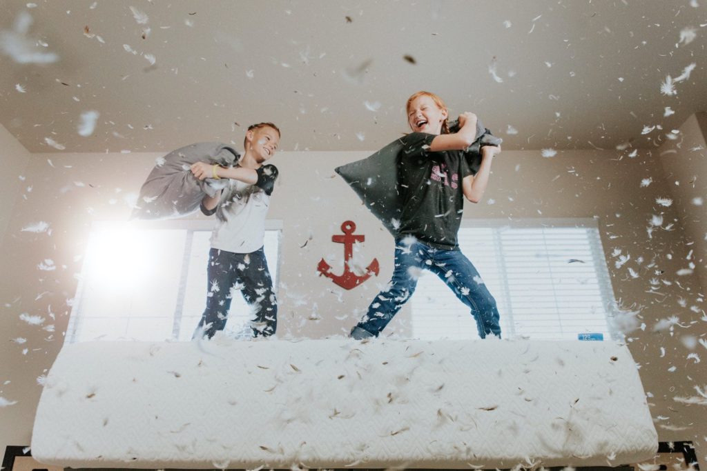 Two kids having pillow fight