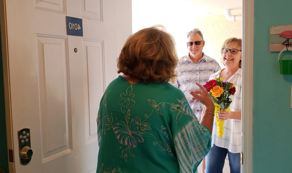 Someone welcoming people with gift to their home