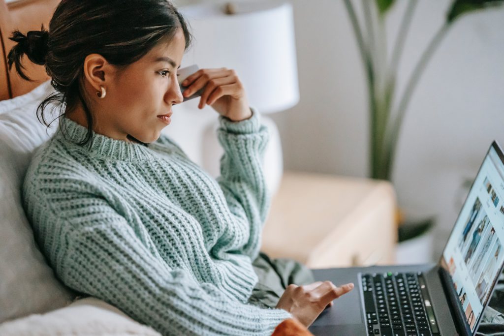 A photo of a woman looking at a laptop to show searching for the best vacation rental insurance